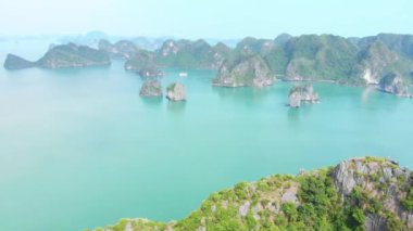 Hava: Ha Long Körfezi üzerinde eşsiz bir uçuş, Vietnam 'daki ünlü turizm merkezi. Açık gökyüzü sisi. Sahne kireçtaşı tepeleri denizde, karst adaları deniz manzarası zirvelerinde. Tekne gezisi.