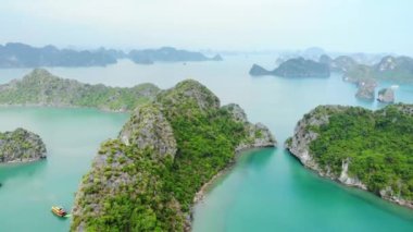 Hava: Ha Long Körfezi üzerinde eşsiz bir uçuş, Vietnam 'daki ünlü turizm merkezi. Açık gökyüzü sisi. Sahne kireçtaşı tepeleri denizde, karst adaları deniz manzarası zirvelerinde. Tekne gezisi.