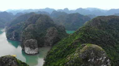Hava: Ha Long Körfezi üzerinde eşsiz bir uçuş, Vietnam 'daki ünlü turizm merkezi. Açık gökyüzü sisi. Sahne kireçtaşı tepeleri denizde, karst adaları deniz manzarası zirvelerinde. Tekne gezisi