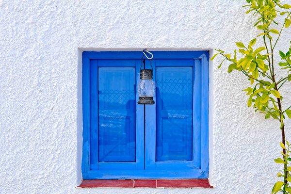 Lamp, lamp, hanging on a blue window in Nijar, Almeria, Andalusia, Spain.