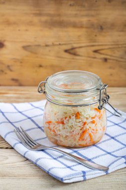 Tahta bir masanın üzerinde cam kavanozlarda duran lahana.