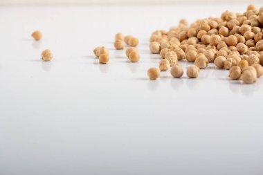 Kurumuş bezelyeler beyaz arka plana saçılmış.