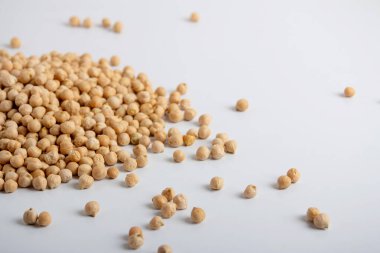 Kurumuş bezelyeler beyaz arka plana saçılmış.