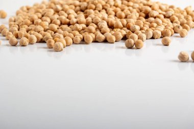 Kurumuş bezelyeler beyaz arka plana saçılmış.