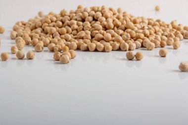 Kurumuş bezelyeler beyaz arka plana saçılmış.