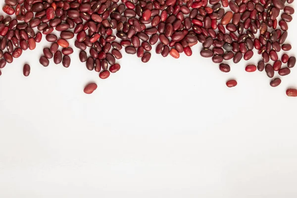 Frijoles rojos crudos salpicados sobre un fondo blanco —  Fotos de Stock