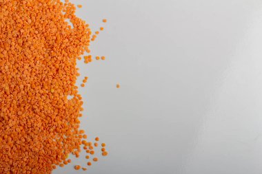 Beyaz arka plana saçılmış çiğ kırmızı mercimek.