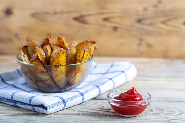 Batatas fritas com ketchup em uma toalha branca em uma mesa de madeira com espaço de cópia Imagens Royalty-Free
