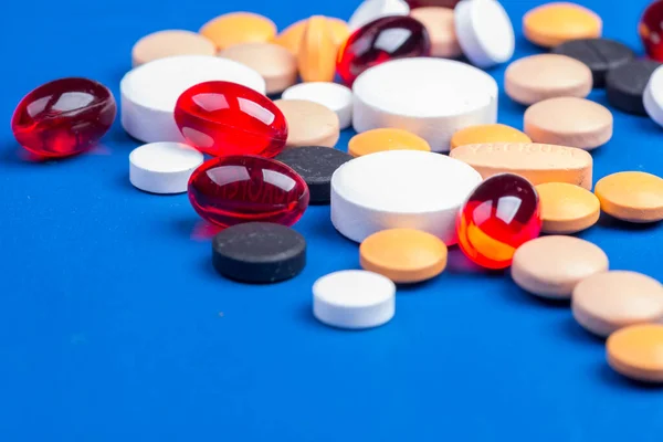 Wegwerp medische masker en blister met witte pillen liggen op een blauwe achtergrond — Stockfoto