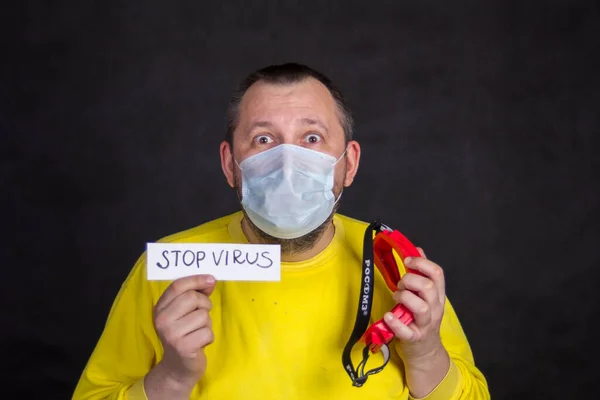 Tek kullanımlık maskeli orta yaşlı bir adam ve sarı ceketli bir adam.