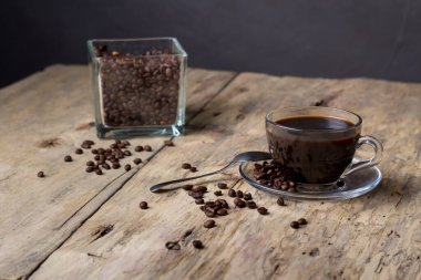 Ahşap bir masada şeffaf cam bir fincanda kahve.