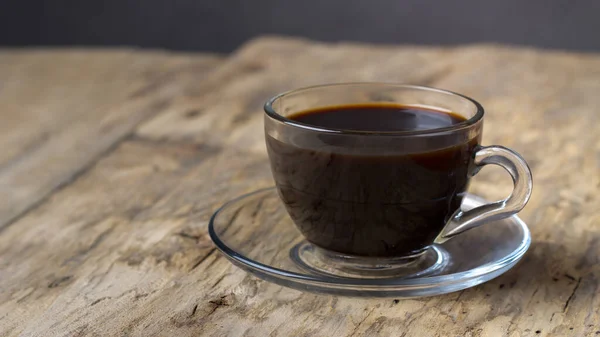 Coffee in a transparent glass cup on a wooden table — Stock Photo, Image