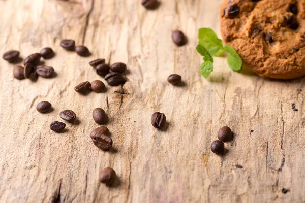 Granos de café espolvoreados sobre una tabla de madera — Foto de Stock