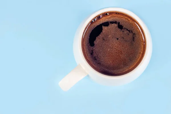 Black coffee in a white mug on a blue background — Stock Photo, Image
