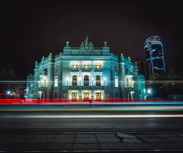 Senderos de luz de los coches que pasan frente a la Ópera Académica de Ekaterimburgo y el Teatro de Ballet por la noche Fotos De Stock