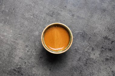 Gri arkaplanda yeşilimsi mavi bardakta Espresso.