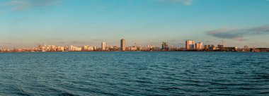 Yekaterinburg şehrinin panoramik manzarası gün batımında rıhtımdan gökyüzüne yükseliyor.