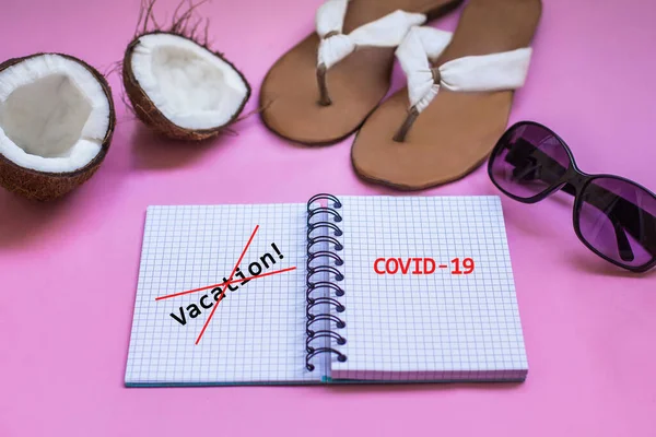 Vacation and travel concept. Traveling kit. Note book with summer shoes, sunglasses, exotic fruit coconut on the pink background.