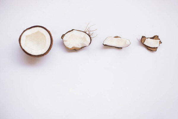 Pieces of coconut on white background, top view. 