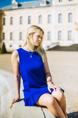 Yazın güzel sarayda güzel bir kızın portresi. Tatilde mavi elbiseli güzel bir bayan. Avrupa 'daki muhteşem saray. Güzel tatil.