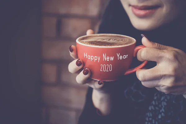 Tangan wanita memegang secangkir kopi latte merah, Selamat Tahun Baru 2020 — Stok Foto
