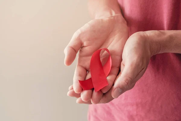Eller kırmızı kurdele tutuyor HIV farkındalığı konsepti, Dünya Yardım Günü, — Stok fotoğraf