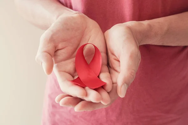 Manos con cinta roja, concepto de concienciación sobre el VIH, día mundial del SIDA , — Foto de Stock