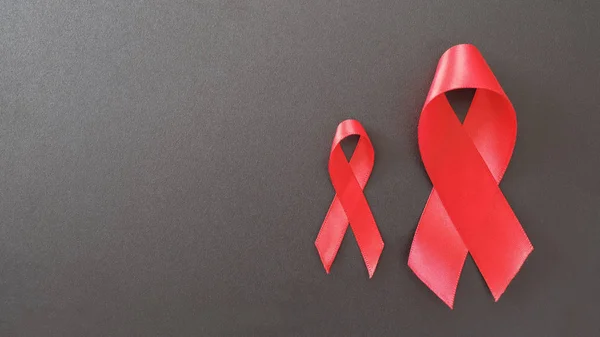 Cintas rojas sobre fondo negro, concepto de conciencia de VIH, AI mundo —  Fotos de Stock