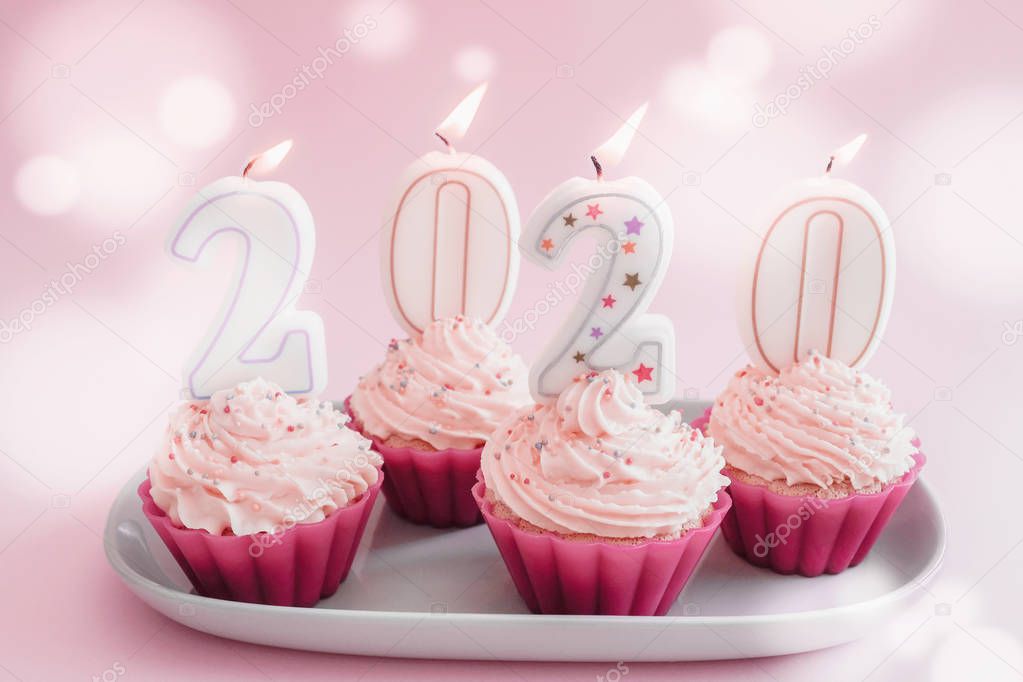 2020 candles on cupcakes with whip cream frosting using pink sil