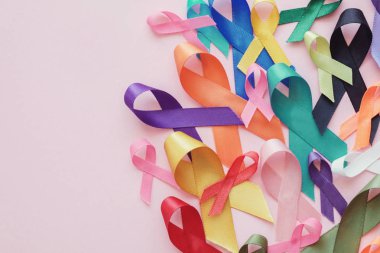 Pembe arka planda renkli kurdeleler, kanser farkındalığı, dünya