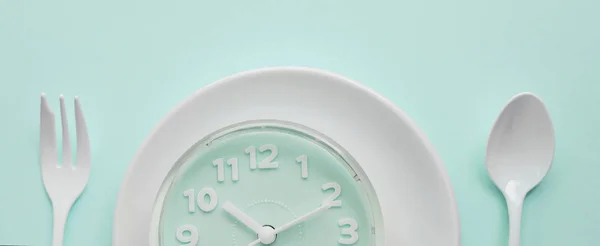 Modré hodiny na bílém talíři s vidličkou a lžící, přerušovaně rychlé — Stock fotografie