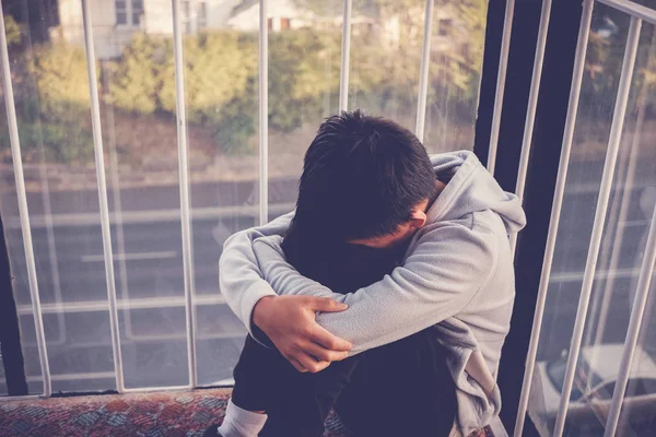 Depressed young preteen teenage boy hugging his knee , children — Stock Photo, Image