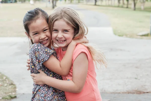 Happy and healthy mixed race young little girls hugging and smil — Stock Photo, Image