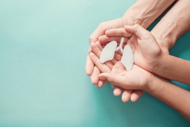 Yetişkin ve çocuk elleri akciğer tutuyor, dünya verem günü, dünya tütün günü yok, Corona covid-19 virüsü, eko hava kirliliği; organ bağışı konsepti