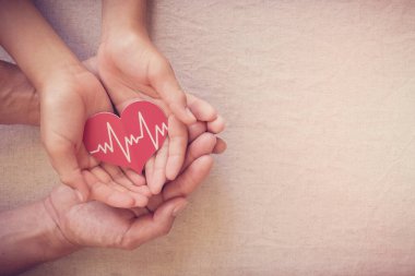 Kırmızı kalbi kardiyogramda tutan eller, sağlık sigortası iş konsepti, dünya kalp günü, dünya sağlık günü