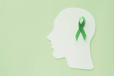 brain paper cutout with green ribbon on green background,  mental health concept, world mental health day clipart