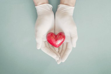 Ellerinde kırmızı kalp, sağlık sigortası, bağışta bulunan doktor elleri, kovid 19 koronavirüs salgını sırasında yardım eli, hayat kurtarma, doktor için teşekkür ederim.