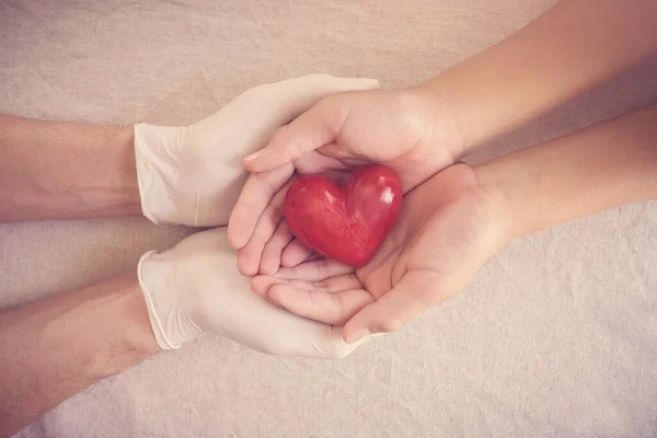 Artsenhanden Met Medische Handschoenen Die Kinderhanden Rode Hart Ziektekostenverzekering Donatie — Stockfoto