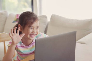 Evde bilgisayarla online sınıf toplantısı uygulaması, sosyal uzaklık, evde eğitim, covid-19 Coronavirus sırasında uzaktan öğrenme, yeni normal konsept kullanarak görüntülü arama yapan bir kız.