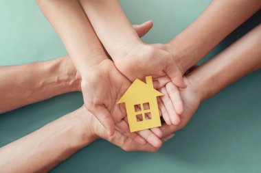 Yetişkinler ve çocuklar kağıt ev, aile evi, evsiz barınağı ve ev koruma konsepti, uluslararası aileler günü, koruyucu aile, evde eğitim, sosyal uzaklık 
