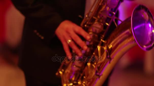 Musician is playing on saxophone in concert. Close-up on fingers pressing the keys of the instrument — Stock Video