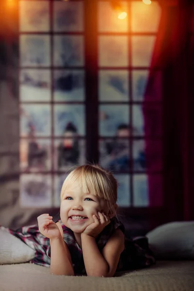 Portrait of cute girl lying barefoot in the bed — Stock Photo, Image