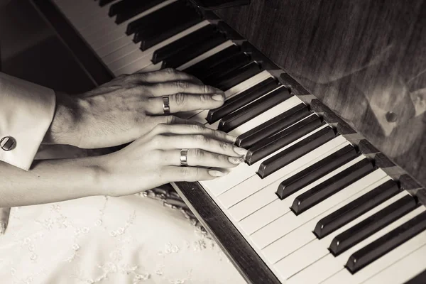 Wedding rings hands groom and bride the piano Stock Picture