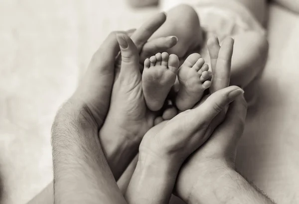 Mãe segurando minúsculo pé de bebê recém-nascido — Fotografia de Stock