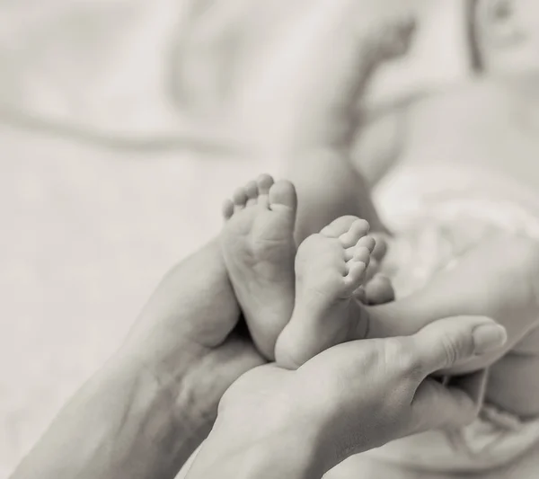 Yeni doğan bebeğin minik ayak tutan anne — Stok fotoğraf