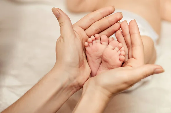 Mãe segurando minúsculo pé de bebê recém-nascido — Fotografia de Stock