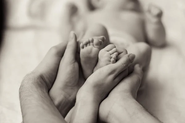 Madre sosteniendo diminuto pie del bebé recién nacido — Foto de Stock