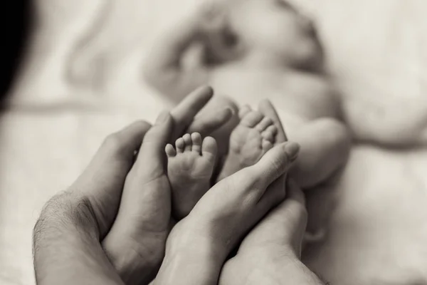 Mãe segurando minúsculo pé de bebê recém-nascido — Fotografia de Stock