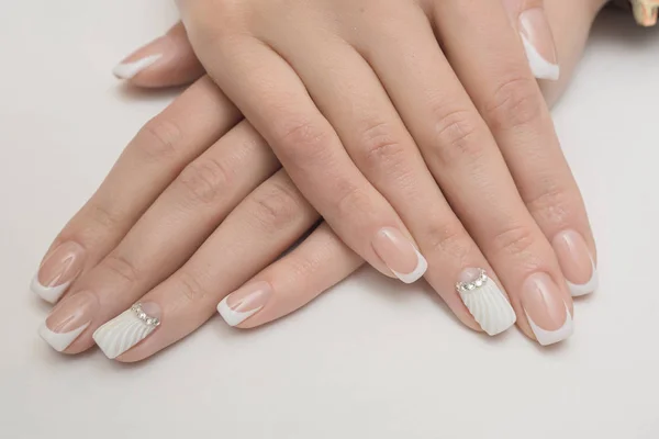 Lichte manicure in licht op een witte achtergrond. — Stockfoto