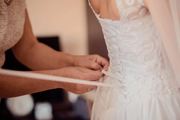 Bridesmaid допомагає нареченій одягатися — стокове фото